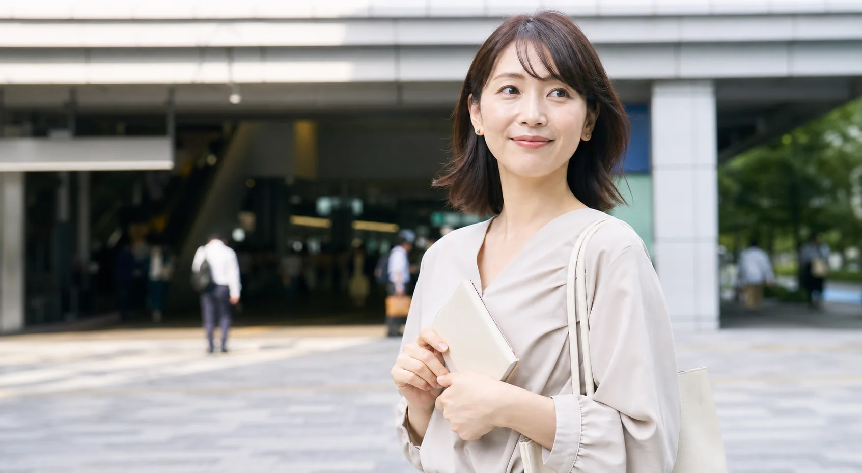 田町駅で待ち合わせを確認する女性